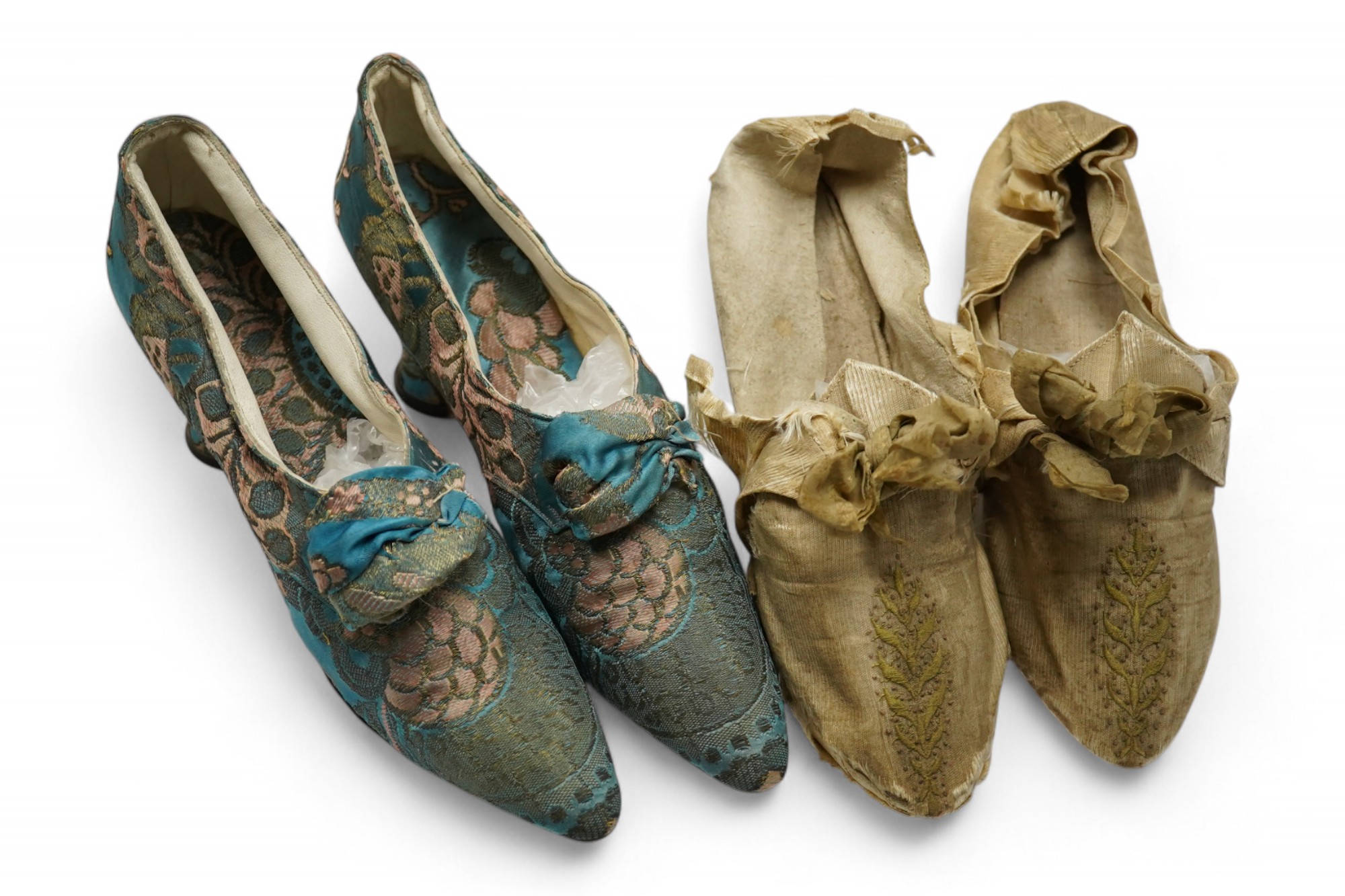 A pair of 18th century cream silk and embroidered ladies shoes together with a later 19th century silk brocade pair of ladies shoes, retailed by C. Moycopf, Burlington Arcade, both pairs lined in soft cream kid leather.